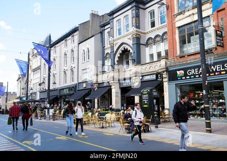 Young people woman wearing covid face mask facemask walking on St Mary Street shops restaurants in Cardiff City Centre May spring 2021  KATHY DEWITT Stock Photo