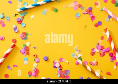 Colorful confetti on yellow background. Stock Photo