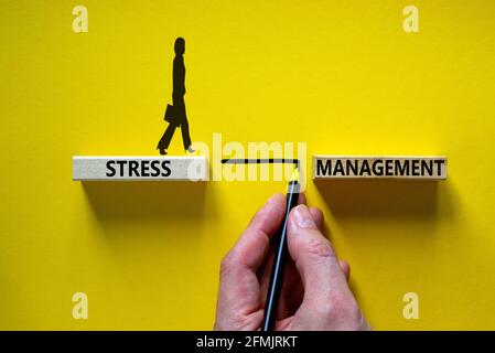 Stress management symbol. Wooden blocks with words 'Stress management'. Yellow background. Businessman hand, businesswoman icon. Psychological, busine Stock Photo