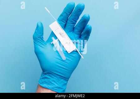 Doctor in blue gloves using a lateral flow covid-19 testing kit Stock Photo