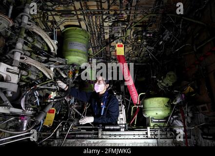 (210510) -- ZHENGZHOU, May 10, 2021 (Xinhua) -- Liu Qiqi works at a maintenance base of the Henan branch of China Southern Airlines in Zhengzhou, central China's Henan Province, April 30, 2021. Liu Qiqi is a 24-year-old mechanic in Henan branch of China Southern Airlines. Graduating from Civil Aviation University of China in 2019, Liu Qiqi is eye-catching in the team, for she is the only female mechanic in the nearly 200-strong maintenance workforce.Working in a traditionally male-dominated industry, Liu was questioned a lot when she entered the profession. The job requires hard graft, and a g Stock Photo