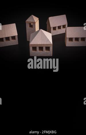 Wooden miniature houses over a black background - real estate concept Stock Photo