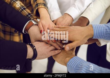Business people or volunteer joined hands together closeup shot top view Stock Photo
