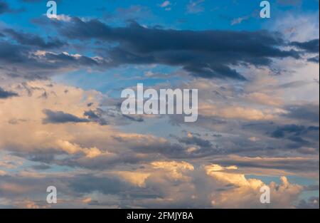 Blue sky with orange colored clouds at sunset after the thunderstorm Stock Photo