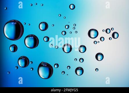 Beautiful coloured diffraction effects from water droplets on glass against a multicoloured background Stock Photo