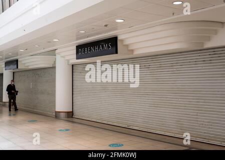 Closed down Debenhams department store inside Eastgate shopping centre in Basildon, Essex, UK. Person with face mask during COVID 19 pandemic Stock Photo