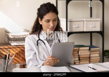 Young woman medical worker use pad study information on website Stock Photo