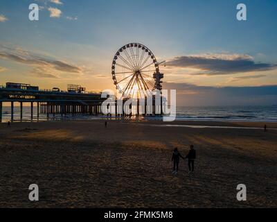 The Ferris Wheel The Pier at Scheveningen, The Hague, The Netherlands on a Spring day, couple man and woman mid age on the beach Stock Photo