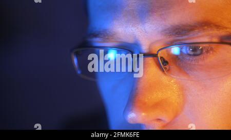 Man in glasses with laptop pc in the evening at home. Stock Photo