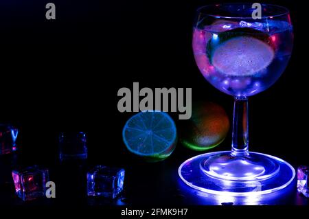 Gin Tonic cocktail in a glass with a lime and ice cubes Stock Photo