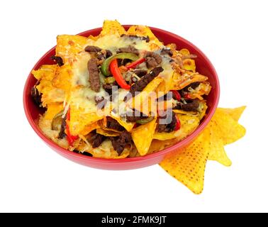 Bowl of beef and cheese nachos with red and green peppers isolated on a white background Stock Photo