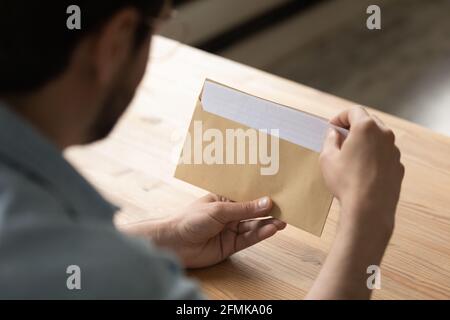 Close up businessman opening envelope with letter, working with correspondence Stock Photo