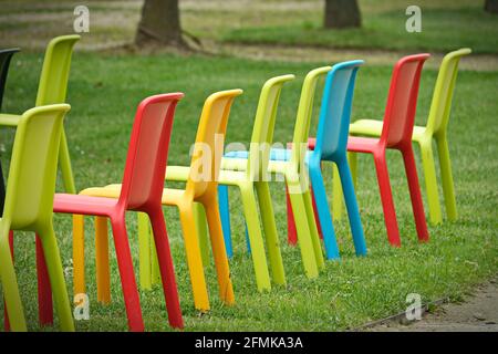 Row of multicolored empty chairs for an outdoor event Stock Photo