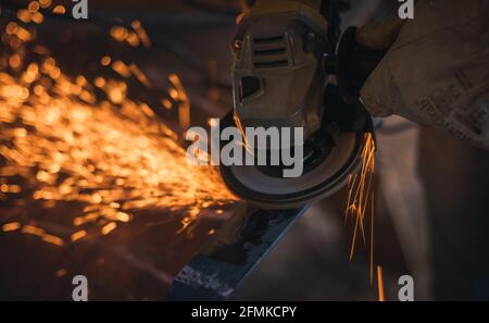 Working in a piece of iron with a grinding machine Stock Photo