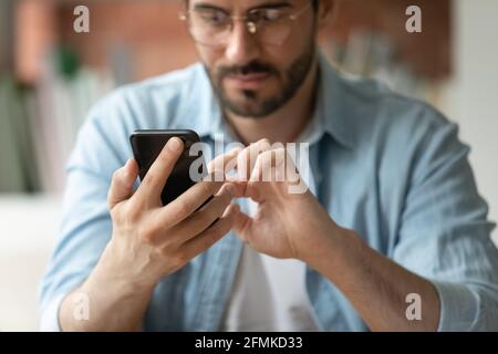 Close up cropped of confident businessman in glasses using smartphone Stock Photo