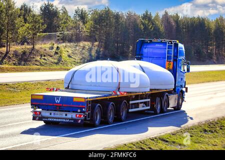 Blue Scania semi trailer truck transporting circular steel objects as oversize load, rear view. Salo, Finland. April 30, 2021. Stock Photo