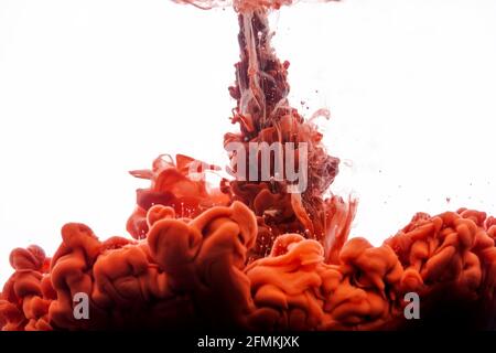 Ink in water. Abstract background. Ink swirling in water. Ink in water isolated on white background. Orange ink in water. Stock Photo