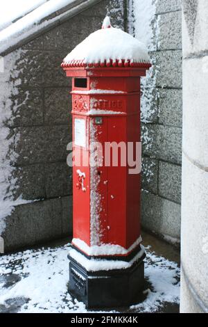 Snow settled on a traditional British red pillar box (post box) situated on the southern side of Tower Bridge, London, UK in February 2009 Stock Photo
