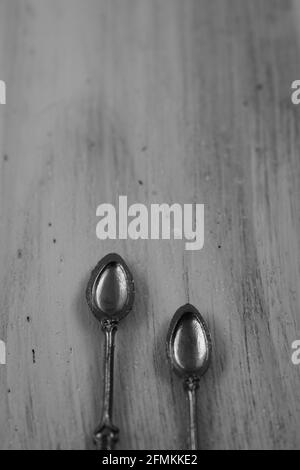 Two silver spoons over vintage wooden background with copy space Stock Photo
