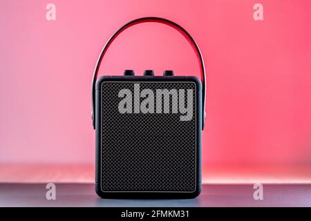 Black modern bluetooth loudspeaker on a pinkish background Stock Photo