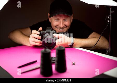 A photographer taking a photo of black tailoring accessories in the studio Stock Photo