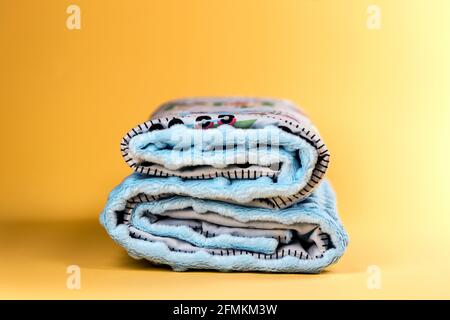 Sweet and cozy baby blanket with pattern isolated on yellow background Stock Photo