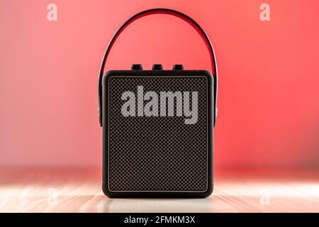 Black modern bluetooth loudspeaker on a reddish background Stock Photo