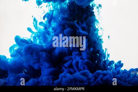 Ink in water. Abstract background. Ink swirling in water. Ink in water isolated on white background. Blue ink in water. Stock Photo