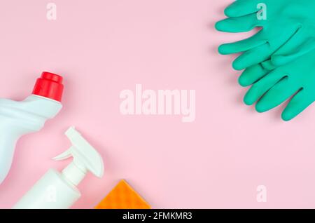 Cleaning products on a pink background. White bottles with detergents and cleaning products, sponges and gloves on a rose background with place for te Stock Photo