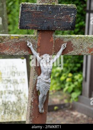 iron effigy of weathered Jesus Christ on an old wooden cross Stock Photo