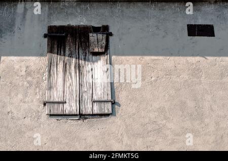 window with old wooden shutters on the concrete wall Stock Photo