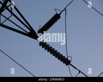 Metallic towers supporting the copper cables that carry electric power; towers over the blue sky: High voltage towers, engineering work to support the Stock Photo