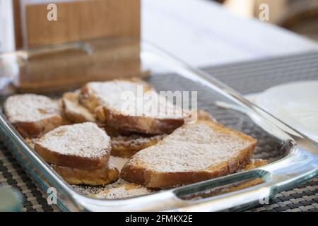 French toasts in glass tray at breakfast table. Homemade sweet dessert concept Stock Photo