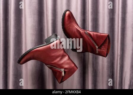 Levitating leather female boots against grey fabric Stock Photo