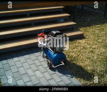 A portable air compressor abanoned outside a house, daylight shot Stock Photo