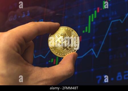 Businessman hold bitcoin on chart stock graph background, crypto exchange and trading concept business photo Stock Photo