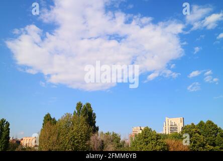 White clouds floating on sunny blue sky over the city Stock Photo