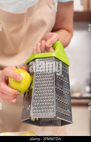 Process of grating an apple. Chef's hands. Stock Photo