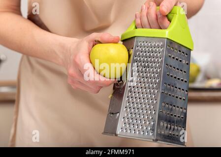Chef grates an apple to make an apple pie Stock Photo