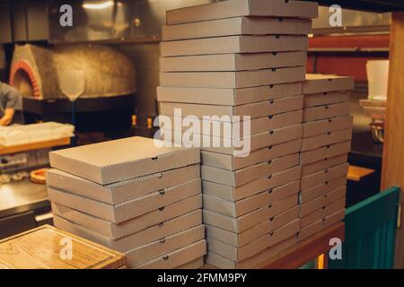 Pizzas cardboard boxes for shipping and delivery. a lot of packaging is on the kitchen stock Stock Photo