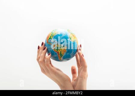 Beautyful female hand holds globe. World in human hands. White background. Stock Photo