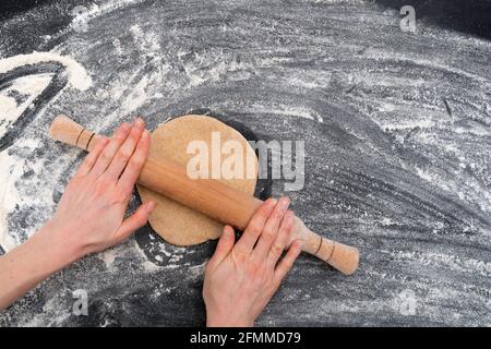 Wome's hands rolling out dough for shortbread cookies. Homemade baking Stock Photo