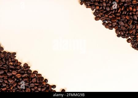 Fresh roasted brown coffee beans as a frame with copy space on light background. Stock Photo