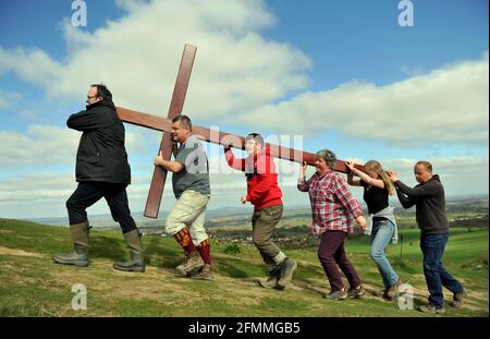 Carrying a wooden cross up Cam Peak on Good Friday before Easter Sunday in a walk of witness, Gloucestershire Stock Photo