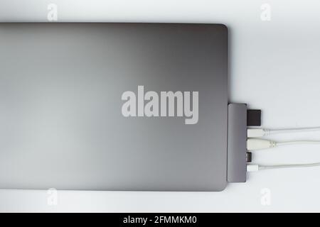 Close-up photo of type-c hub with white cables and card connected to laptop Stock Photo