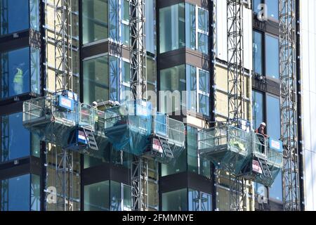 Construction workers in cradles building a high-rise apartment block in Woolwich. London Stock Photo