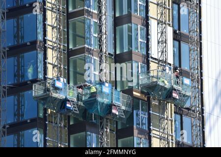 Construction workers in cradles building a high-rise apartment block in Woolwich. London Stock Photo