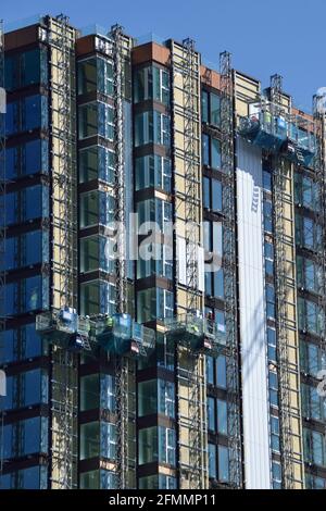 Construction workers in cradles building a high-rise apartment block in Woolwich. London Stock Photo
