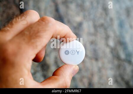 Man pov looking at AirTag with printed KEy text Stock Photo