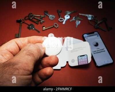 Man pov looking at AirTag with printed emoji key Stock Photo